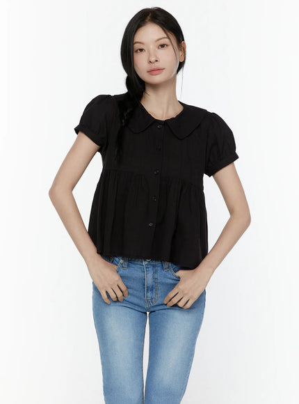 Puff Sleeve Blouse IL506 Black front full-body shot on model with hands in pockets, peter pan collar, button-front peplum top styled with blue straight jeans, neutral pose