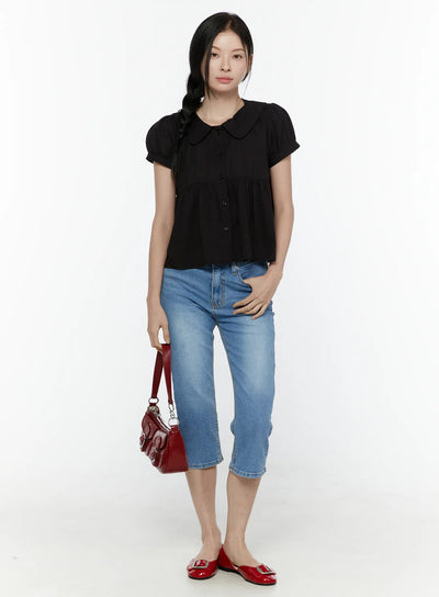 LEWKIN Puff Sleeve Blouse IL506 Black front full-body shot on model with braided hair, peter pan collar, button-front, peplum hem, styled with blue cropped jeans and red flats