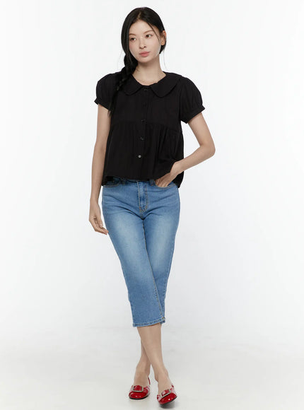 Puff Sleeve Blouse IL506 Black front full-body shot on model looking sideways, peter pan collar and button-front peplum silhouette, paired with blue cropped jeans and red flats
