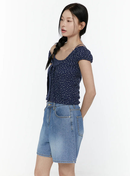 Puff Sleeve Floral Cami Top IL506 Navy side shot on model with hands behind back, ditsy floral print and cold-shoulder puff sleeve in navy colorway