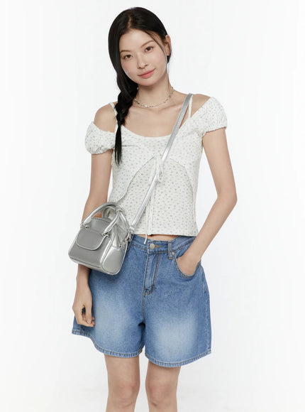 Puff Sleeve Floral Cami Top IL506 White three-quarter front shot on model carrying silver handbag, front tie detail and cold-shoulder puff sleeves
