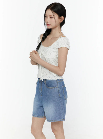 Puff Sleeve Floral Cami Top IL506 White side shot on model with hands on braid, cold-shoulder puff sleeve silhouette and front tie detail visible