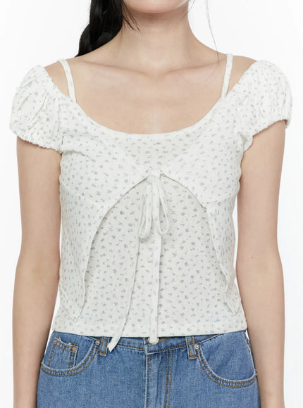 Puff Sleeve Floral Cami Top IL506 White close-up front detail on model showing spaghetti straps, ruched puff sleeves, and center ribbon tie closure