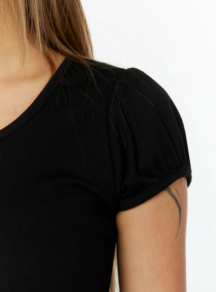 Puff Sleeve Henley Tee IL524 Black close-up detail shot on model showing gathered puff cap sleeve construction and ribbed fabric texture