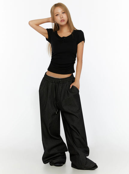 Puff Sleeve Henley Tee IL524 Black full-body front shot on model arm raised behind head styled with dark oversized wide-leg drawstring denim pants