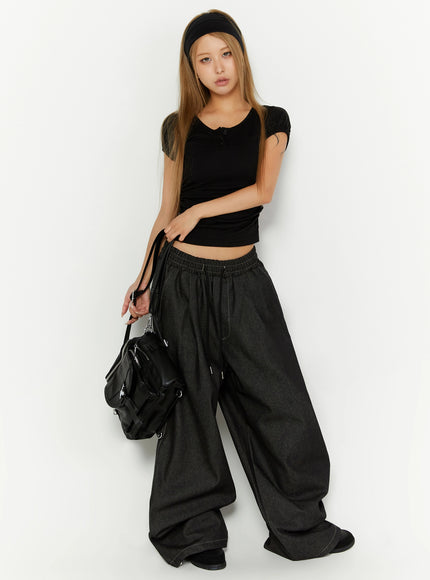 Puff Sleeve Henley Tee IL524 Black full-body front shot on model holding black bag with headband styled with oversized dark denim wide-leg pants