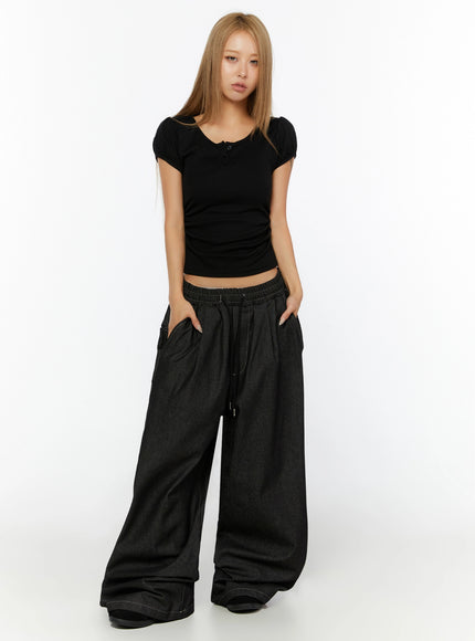 Puff Sleeve Henley Tee IL524 Black full-body front shot on model hands in pockets showing ruched sides and crop length with dark wide-leg denim