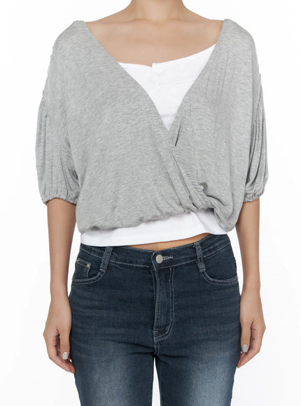 Puff Wrap V-Neck Tee CL510 Gray headless front detail shot on model highlighting crossover wrap V-neck, voluminous puff sleeves, cropped hemline, layered over white cami with dark fitted jeans