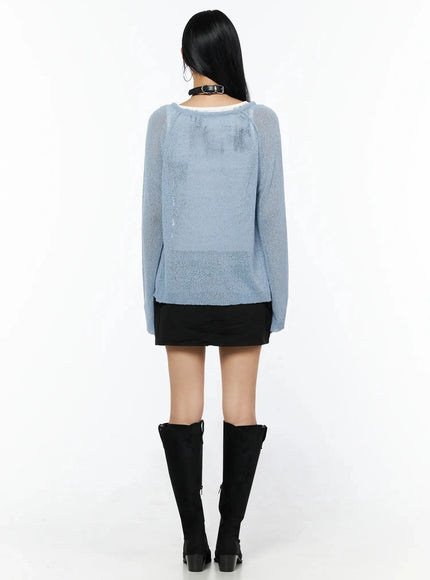 Raglan Sheer Open Knit Cardigan IL509 Light blue back shot model showing rear view of sheer knit fabric raglan sleeves and cropped hem over white tank and black mini skirt