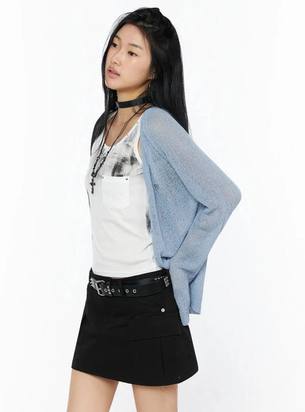 Raglan Sheer Open Knit Cardigan IL509 Light blue side shot model hand on hip showing silhouette and sheer open-knit texture layered over white tank and black mini skirt