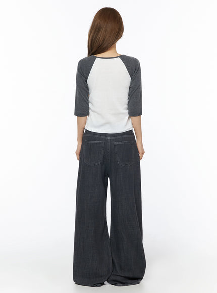 Raglan Shirred 3/4 Top IU525 White back full-body on model showing rear view of white body, charcoal raglan sleeves, and scoop neckline, styled with dark wide-leg jeans