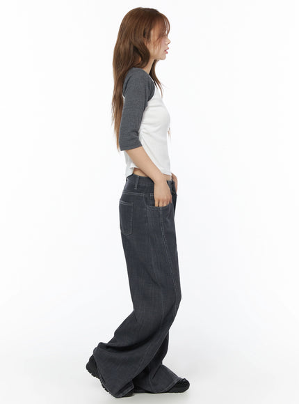Raglan Shirred 3/4 Top IU525 White side full-body on model with long hair, showing crop length and raglan sleeve seam, paired with wide-leg dark denim, hand in pocket