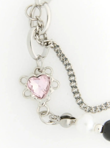 Raven Halloween Bracelet IL522 black close-up detail of pink faceted heart crystal charm with ornate silver flower-shaped setting and oval link chain