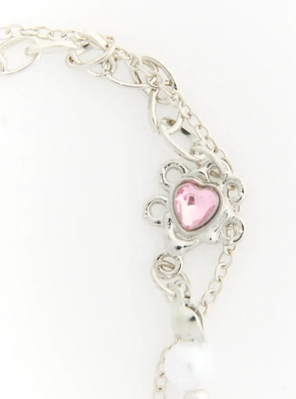Raven Halloween Bracelet IL522 white close-up detail of ornate silver flower connector with pink heart crystal center on oval link chain next to white pearl beads