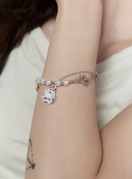 Raven Halloween Bracelet IL522 white on-model close-up wrist shot showing white ghost charm with pink crystals, pearl beads, and pink heart connector on model's wrist