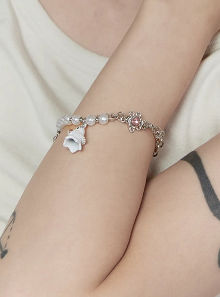 Raven Halloween Bracelet IL522 white on-model wrist shot showing white ghost charm and pink heart crystal on pearl bead and silver chain bracelet worn on model's wrist