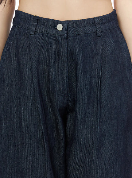 Relaxed-Fit Wide-Leg Pants IU525 Dark blue close-up detail shot of waistband showing silver snap button double pleats and twill denim texture