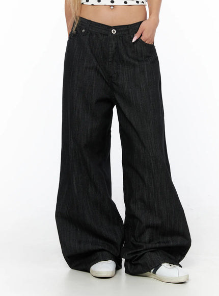 Rene Studded Wide Leg Jeans CU524 Black front waist-down view on model with hand in pocket showing V-notch waistband and extreme wide-leg denim hem