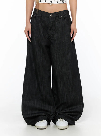 Rene Studded Wide Leg Jeans CU524 Black front close-up on model showing V-notch low waistband, wide-leg denim drape pooling at white sneakers