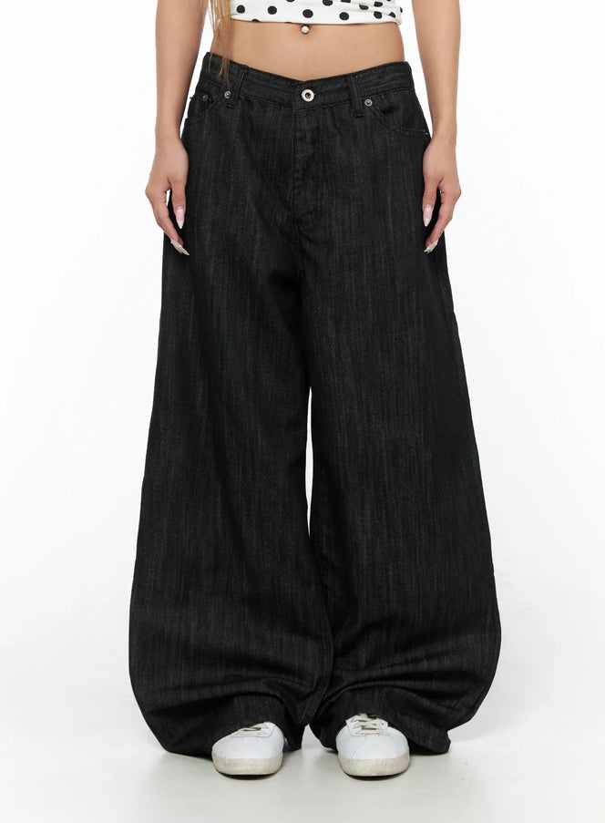 Rene Studded Wide Leg Jeans CU524 Black front close-up on model showing V-notch low waistband, wide-leg denim drape pooling at white sneakers