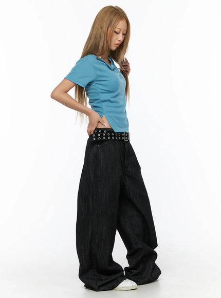 Rene Studded Wide Leg Jeans CU524 Black side view on model in blue polo looking down, grommet belt detail and voluminous wide-leg denim silhouette