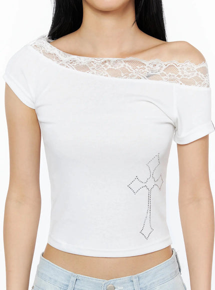 Rhinestone Cross Lace Trim Off-Shoulder Top IL516 White close-up front shot on model showing floral lace trim neckline transparent lace yoke and silver rhinestone cross detail on crop body