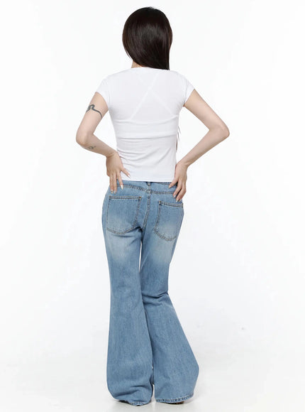 Rhinestone Graphic Tee IL506 White back shot on model hands on hips, plain white cropped back panel with clean seam detail tucked above low-rise flare jeans