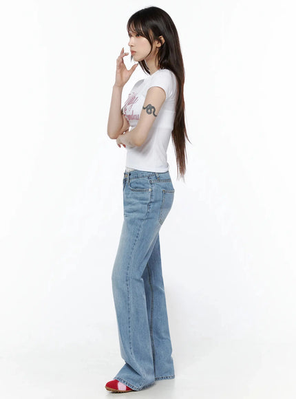 Rhinestone Graphic Tee IL506 White side shot on model with hand raised near face, fitted crop silhouette visible paired with flare jeans and red shoes