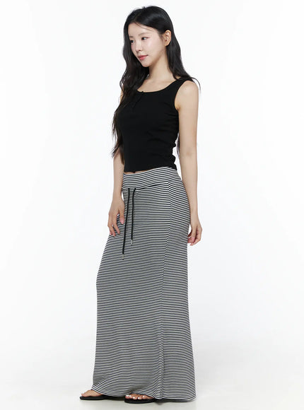 Ribbed Button Tank Top IU525 Black three-quarter side model shot looking away showing fitted crop length and rib texture styled with striped maxi skirt