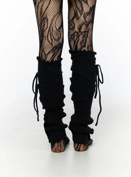 Ribbed Buttoned Leg Warmers CL523 Black back close-up both legs on model showing rear lace-up cord detail and ruched ribbed texture over floral fishnet tights