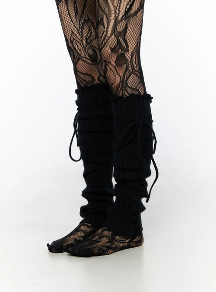 LEWKIN Ribbed Buttoned Leg Warmers CL523 Black side-view close-up on model worn over floral fishnet tights with lace-up cord detail at calf