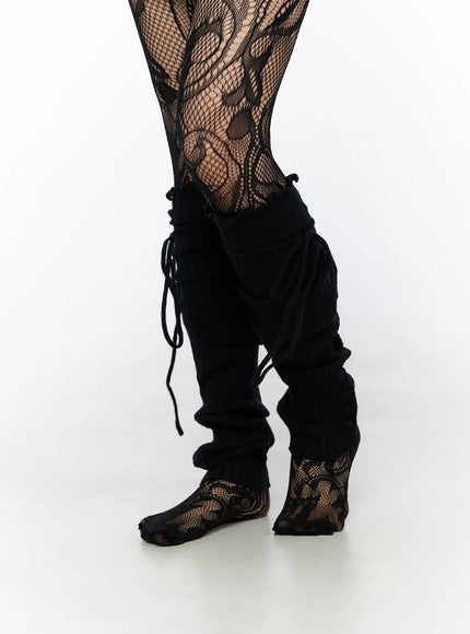Ribbed Buttoned Leg Warmers CL523 Black side close-up on model showing leg warmer pulled down slouched over floral fishnet tights with loose cord ties