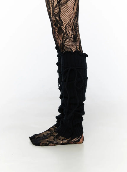 Ribbed Buttoned Leg Warmers CL523 Black side close-up single leg on model showing full length ribbed knit leg warmer with lace-up cord over fishnet tights