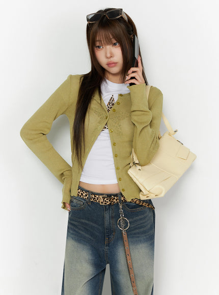 LEWKIN Ribbed Cardigan IL523 Dark green S/M front shot on model holding phone, open over white crop tee, layered ribbed knit texture with gold buttons