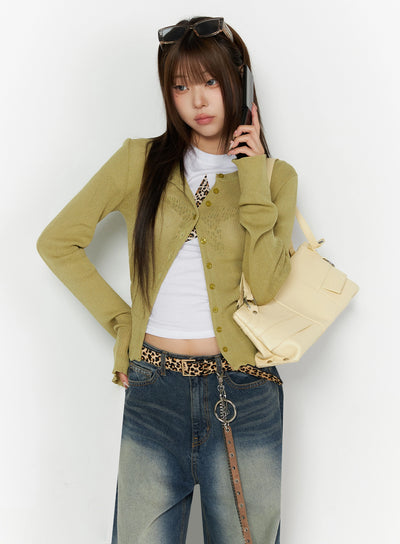 LEWKIN Ribbed Cardigan IL523 Dark green S/M front shot on model holding phone, open over white crop tee, layered ribbed knit texture with gold buttons
