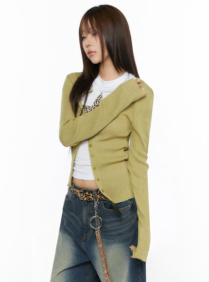 Ribbed Cardigan IL523 Dark green S/M side shot on model with arms crossed, ribbed knit cardigan open, button placket and slim silhouette visible, styled with jeans