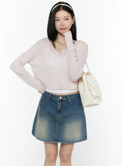 LEWKIN Ribbed Crop Cardigan IL506 Light pink front model shot three-quarter bust pose with headband ribbed knit texture button front cropped silhouette styled with denim mini skirt and white bucket bag