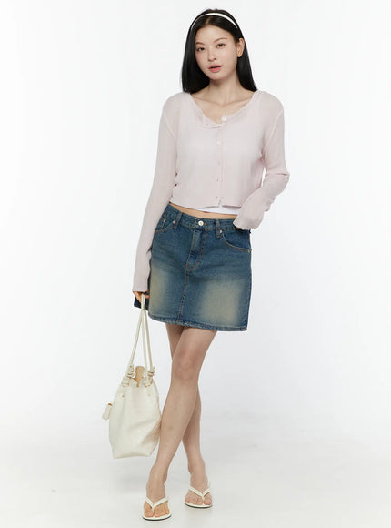 Ribbed Crop Cardigan IL506 Light pink full-body front model shot with headband carrying white bucket bag standing pose showing ribbed knit crop cardigan and denim mini skirt with flip-flops