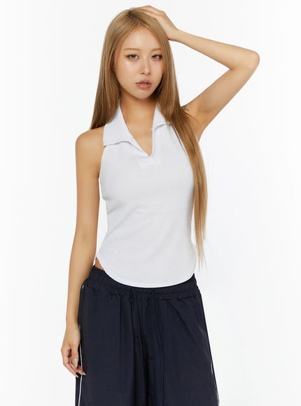 Ribbed Halter Neck Top IL524 White front shot on model with hand raised to head, sleeveless halter silhouette with polo collar and ribbed body