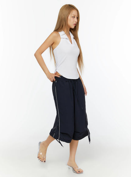 Ribbed Halter Neck Top IL524 White full-length side shot on model stepping forward, showing wide navy cropped trousers with tie hem and white piping