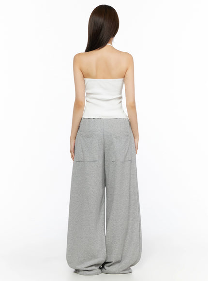 Ribbed Halter Sleeveless Top IL515 White back shot on model revealing open back halter tie detail and wide ribbed hem above gray sweatpants