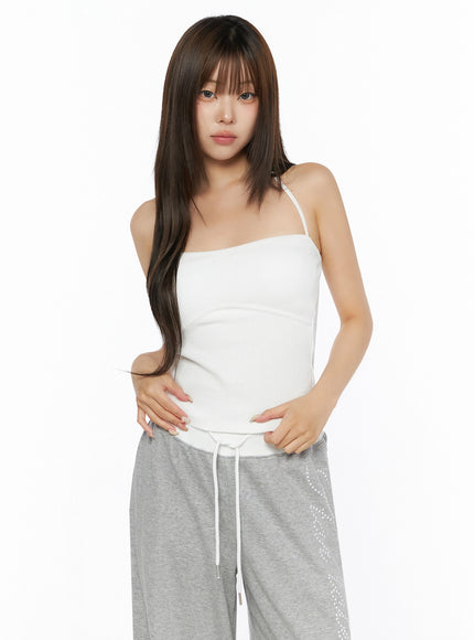 Ribbed Halter Sleeveless Top IL515 White front shot on model with hands on waist showing fitted ribbed silhouette and halter neck tie
