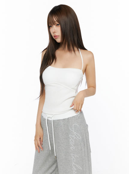 Ribbed Halter Sleeveless Top IL515 White angled side-front shot on model looking over shoulder paired with gray wide-leg sweatpants