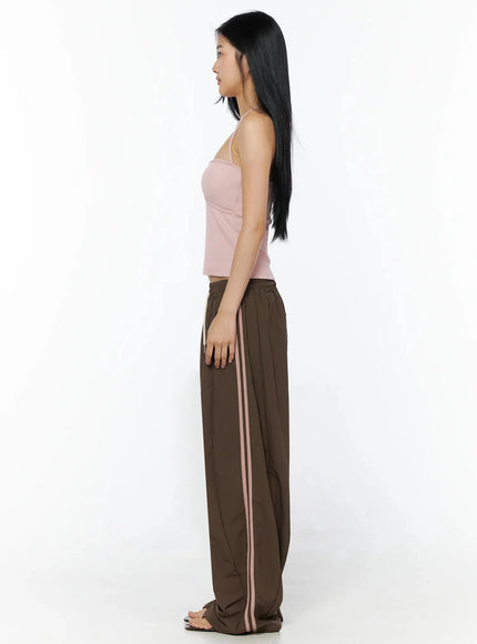 Ribbed Halter Top IL509 Pink side view model standing profile showing halter neck tie open back ribbed crop silhouette with brown stripe trousers
