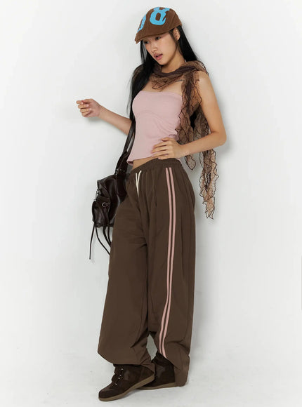 Ribbed Halter Top IL509 Pink full-length styled shot model with lace scarf cap and leather bag wearing pink ribbed halter crop top with brown side-stripe trousers