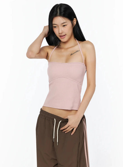 Ribbed Halter Top IL509 Pink three-quarter front view model hand in hair gazing down showing ribbed halter crop silhouette and corset-style seam