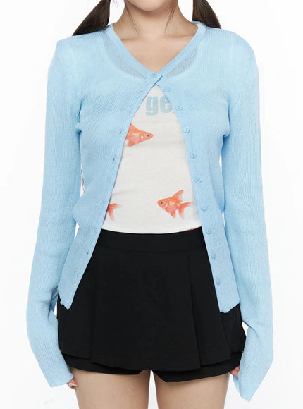 Ribbed Round Neck Cardigan IL515 Light blue close-up front detail shot on model showing V-neckline, button placket, sheer ribbed knit fabric, open over graphic tank