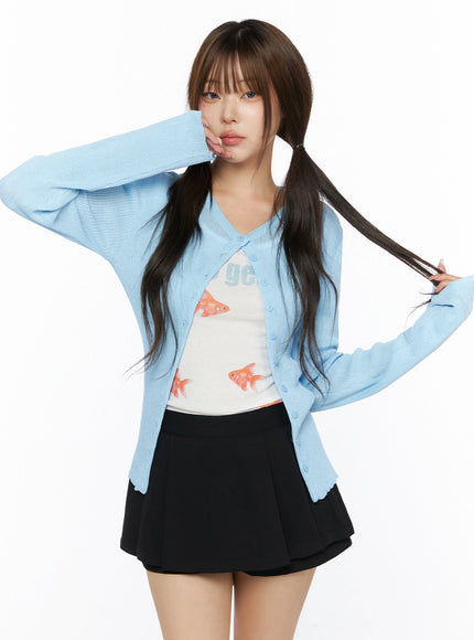 Ribbed Round Neck Cardigan IL515 Light blue upper-body front model shot hands raised to face and hair, V-neck open cardigan with fine ribbed texture