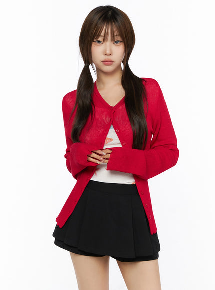 Ribbed Round Neck Cardigan IL515 Red cropped front model shot with arms crossed, V-neckline, button-down closure, sheer ribbed knit texture