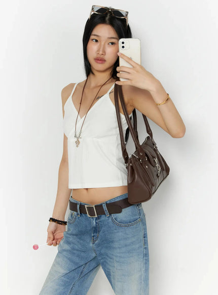 Ribbed Sleeveless Top IL509 White lifestyle mirror-selfie shot, model holding phone with brown bag on shoulder, necklace and belt accessories, front wrap detail visible